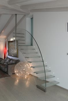 a living room filled with furniture and a spiral stair case in front of a white wall