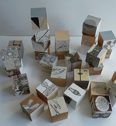 many small boxes are stacked on top of each other and have different designs in them