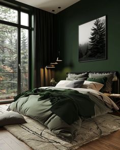 a bedroom with dark green walls and wooden flooring is furnished with a large bed