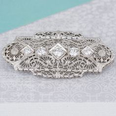 This vintage pin has an added chain loop. It can be tucked away so the brooch can we worn on clothing, or folded out so the piece can be hung from a chain. There are five old cut diamonds set amongst the intricate metal work. Normal price: $1,595.00 Special internet SALE price: $995.00 Metal Type: 14k White Gold Diamond: Round, 0.55ct Diamond color: G/H Diamond clarity: Si1 Item Height: 18.7mm Item Length: 1.5 inches Design Elements: brooch, pendant, filigree Condition: Estate (Excellent conditi Chain Loop, Diamond Brooch, Metal Work, Diamond Color, Vintage Pins, G H, Diamond Clarity, White Gold Diamonds, White Vintage