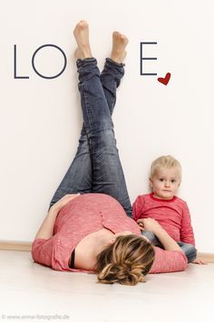 a woman laying on the floor with a child in front of her that says love