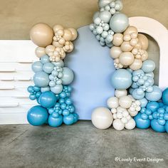 an arch made out of balloons in the shape of a house is displayed against a wall