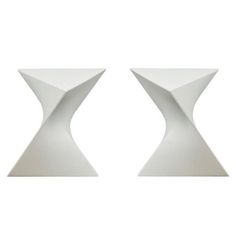 two white vases sitting next to each other on a white surface with one in the middle