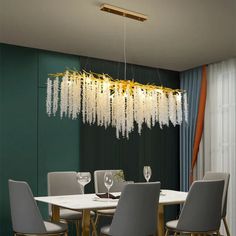 a dining room table with chairs and a chandelier hanging from the ceiling over it