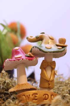 two small figurines are standing next to each other in the grass and one has a hat on it's head