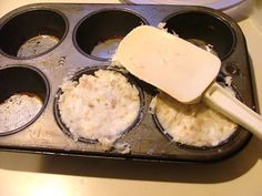 a muffin tin filled with batter and some other food items next to a spatula