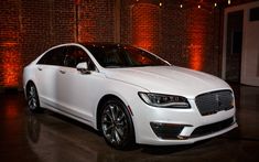 a white car parked in front of a brick wall with red lights on it's side