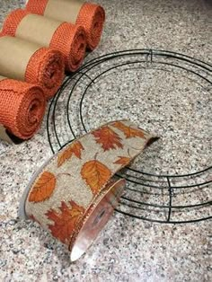 rolls of toilet paper are sitting on the counter next to an orange towel holder and some rolled up towels