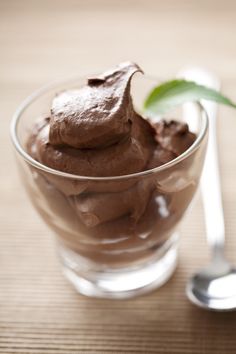 a glass bowl filled with chocolate pudding on top of a table