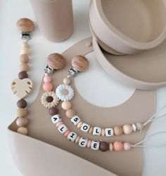 a table topped with different types of beads and wooden items next to cups on top of each other