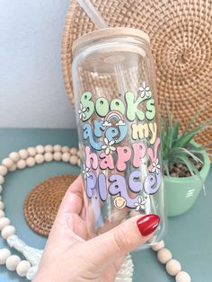 a person holding up a cup with the words boo's happy place on it