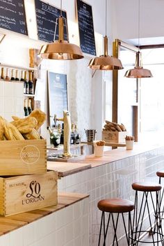 a restaurant with lots of food on the counter and stools in front of it