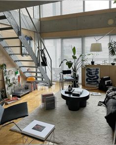 a living room filled with furniture next to a stair case