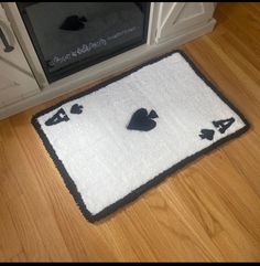 a white rug with black hearts and spades on it in front of a microwave