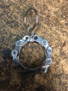 a close up of a metal object on a table with a keychain hanging from it