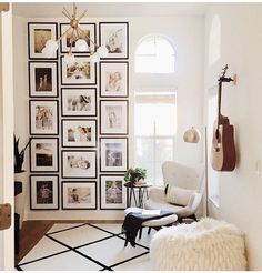 a living room with pictures on the wall and a guitar hanging from the ceiling in front of it