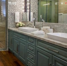 a bathroom with two sinks and a large mirror above the double sink vanity area, along with a walk - in shower