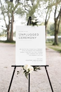 an unplugged ceremony sign with flowers on it