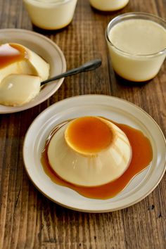 two white plates topped with desserts on top of a wooden table