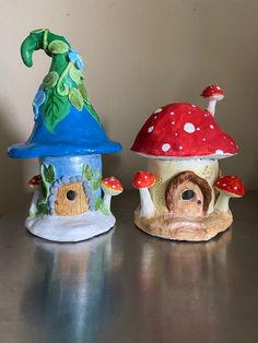 two small mushroom houses sitting on top of a table