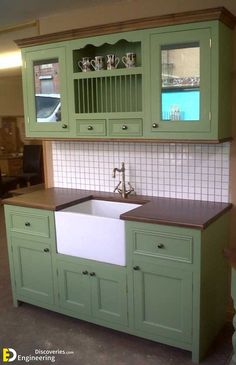 a kitchen with green cabinets and a white sink