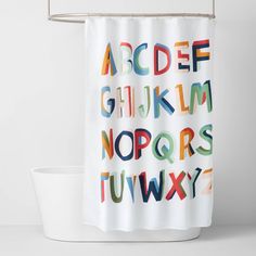 the shower curtain is decorated with letters and numbers in multicolored font on white