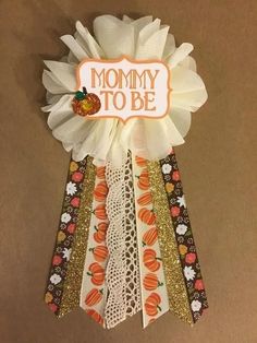 a ribbon with the words mommy to be written on it