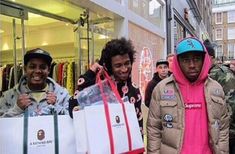 three men carrying shopping bags and smiling at the camera