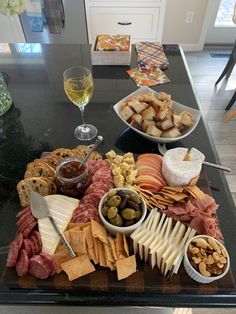 an assortment of cheeses, crackers, and meats on a platter