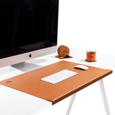 a computer monitor sitting on top of a wooden desk next to a keyboard and mouse