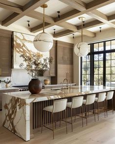 a large kitchen with marble counter tops and white chairs in front of an open window