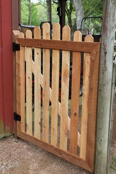 a wooden gate is open on the side of a building