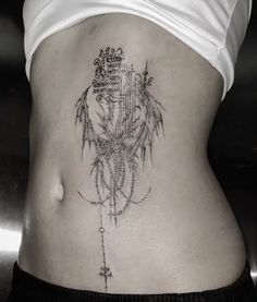 a woman's stomach with an intricate tattoo on it