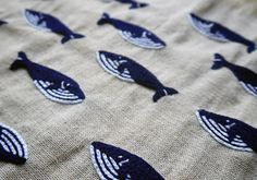 a close up of a cloth with blue fish on it and white stripes in the middle