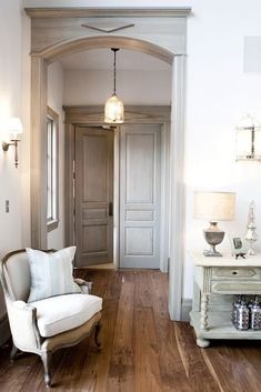 an image of a living room with wood floors and white furniture in the middle of it