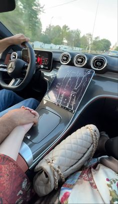 a person sitting in the driver's seat of a car with their feet on the steering wheel