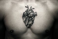 a man's chest with a heart tattoo on it