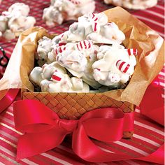 a bowl filled with white chocolate covered in candy canes on top of a red and white table cloth