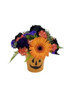 an orange and purple flower arrangement in a pumpkin shaped vase