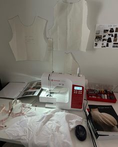 a sewing machine sitting on top of a white table next to a piece of paper