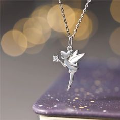 A LITTLE MAGIC WITH THE PIXIE DUST This beautiful necklace is a special and unique piece of jewel for you your best friends and a perfect gift for any occasion. It is made entirely of solid 925 sterling silver. The pendants comes in the shape of the lovely Tinkerbell silhouette with the a pixie gust in her hands. The pixie dust is made with a bright and shiny faceted clear swarovski. The base of the pendant is made of sterling silver with white enameled wings. The necklace is really detailed as Tinkerbell Pixie Dust, Tinkerbell Silhouette, Necklace Fairy, Silver Fairy, Clean Gold Jewelry, Fairy Pendant, Fairy Jewelry, Fairy Necklace, Jewelry Accessories Ideas