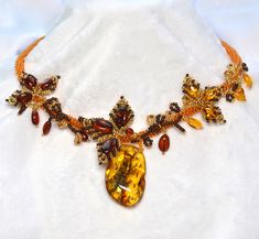 Natural Baltic Amber Handsewn Statement Piece Necklace Behold the allure of inclusions – nature's fingerprints preserved in time, adding a distinctive and ethereal quality to the focal stone. These mesmerizing imperfections tell a story of the earth's journey, creating a visual symphony that is both awe-inspiring and truly one-of-a-kind. Meticulously hand-sewn with love by an Artist from the Baltic Region now residing in Canada, she sourced her Amber from Russia, and the Glass seed Beads are Jap Luxury Handmade Amber Necklace, Handmade Baltic Amber Spiritual Jewelry, Artisan Amber Jewelry With Natural Inclusions, Elegant Handmade Baltic Amber Necklaces, Elegant Baltic Amber Jewelry With Natural Stones, Elegant Handmade Baltic Amber Necklace, Elegant Amber Beads, Gems, And Cabochons, Elegant Round Amber Beads, Gems, And Cabochons, Elegant Round Amber Beads And Cabochons