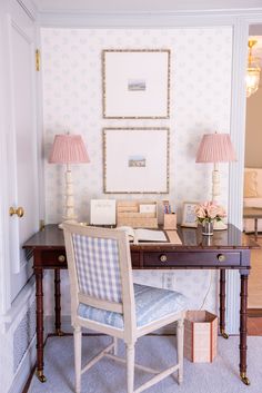 a desk with a chair, lamp and pictures on the wall