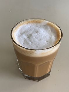 a glass filled with liquid sitting on top of a table