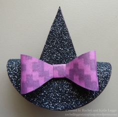 a purple bow tie sitting on top of a black and silver hat with glitters