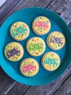 six decorated birthday cookies on a blue plate