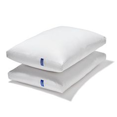 two pillows stacked on top of each other, one is white and the other is blue