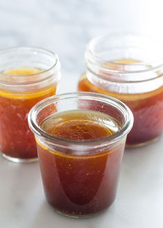 three jars filled with jam sitting on top of a table