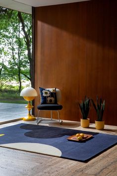 a living room with wood paneling and modern furniture on the floor in front of a large window