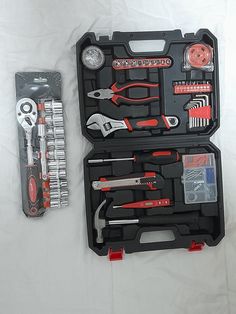 a tool kit with tools in it sitting on a bed